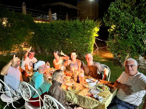 Un groupe de personnes assises autour d'une table avec de la nourriture dans l'établissement Paradis Touareg, à Zagora
