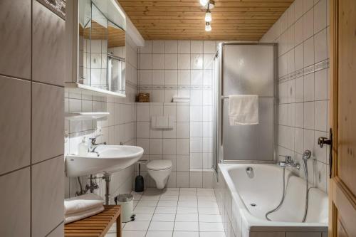 a bathroom with a sink and a tub and a toilet at Gutjahr in Freiamt