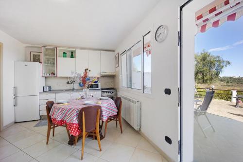 a kitchen with a table and chairs and a kitchen with white appliances at casa vacanza Sanaa in Civezza