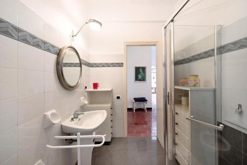 a white bathroom with a sink and a mirror at Casa Nina in Arenzano