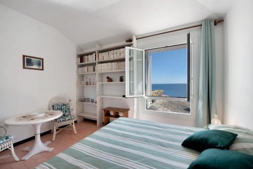 a bedroom with a bed and a window with the ocean at Casa Nina in Arenzano