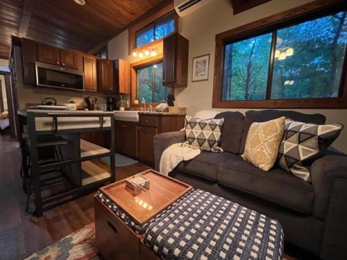 a living room with a couch and a kitchen at Snuggle Up in Broken Bow