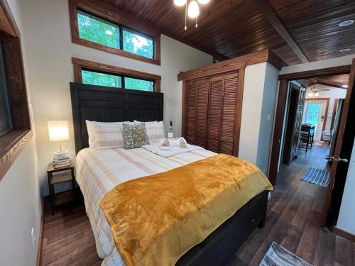 a bedroom with a large bed in a room with windows at Snuggle Up in Broken Bow