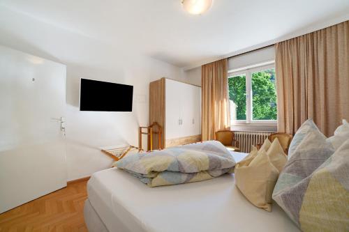 a hotel room with a bed and a television at Villa Sabine - Renate in Merano