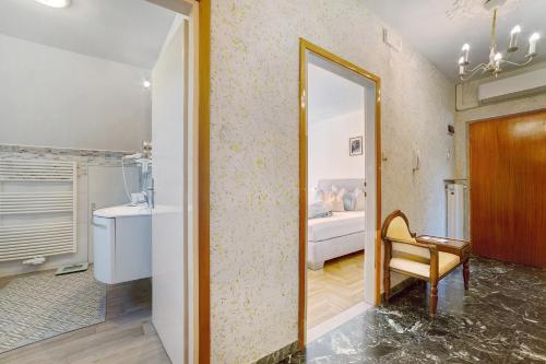 a bathroom with a mirror and a chair in a room at Villa Sabine - Renate in Merano