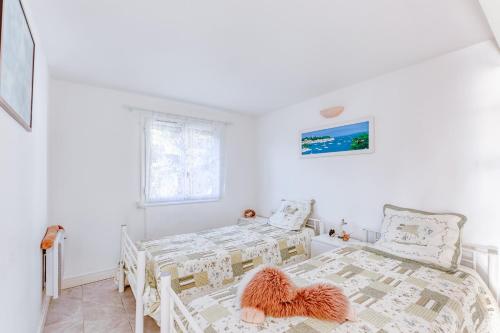 een witte slaapkamer met 2 bedden en een raam bij Villa enchantée du mont des oiseaux in Hyères