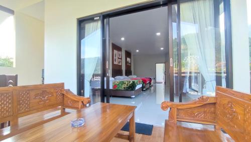 sala de estar con mesa de madera y puertas de cristal en Gubuk Ndeso Homestay, en Bromo