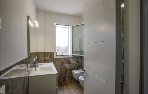 a bathroom with a sink and a toilet and a window at Stunning Home In Appignano Del Tronto With Wifi And 4 Bedrooms in Appignano del Tronto