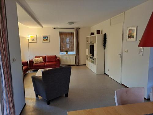 uma sala de estar com um sofá e uma cadeira em Vakantiehuis Arcadia em Zonnemaire