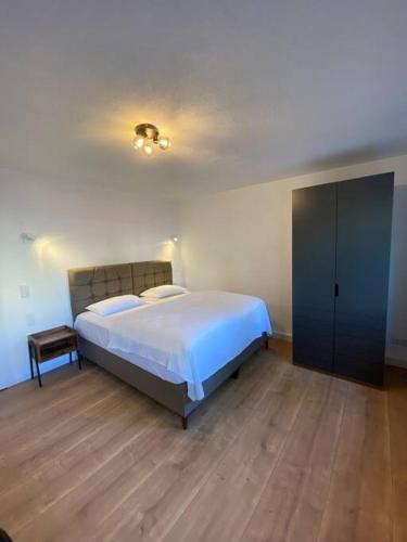 a bedroom with a large white bed and a wooden floor at Nisay Home - 3 Room Apartment - A1 in Ludwigsburg