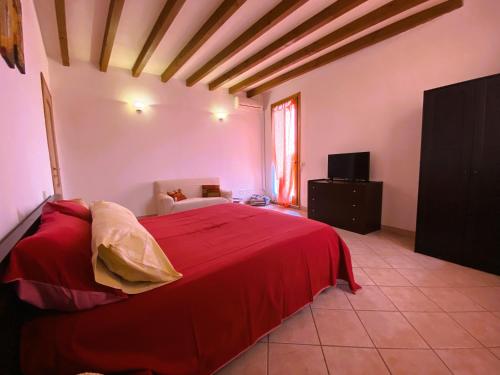 - une chambre avec un lit rouge et une télévision dans l'établissement B&B Tenuta Le Rondini, à Gavardo