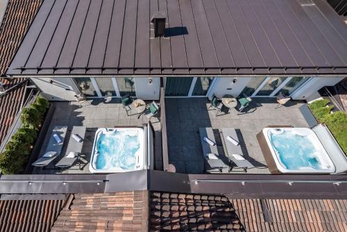 an overhead view of a patio with chairs and a pool at Vitaurina Royal Hotel in Molini di Tures