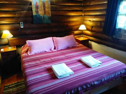 a bedroom with a bed with two towels on it at Quechua Cabañas Funes in Funes