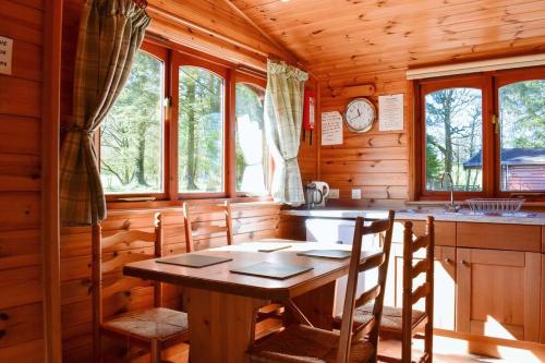 een keuken met een tafel en stoelen in een huisje bij Secluded Pine Lodge 2 in Wigton