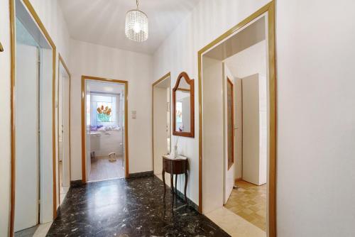 um corredor com paredes brancas, um espelho e uma mesa em Villa Sabine - Karin em Merano