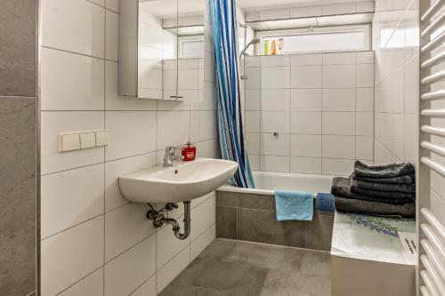 a white bathroom with a sink and a bath tub at Wiesenblick in Radolfzell am Bodensee
