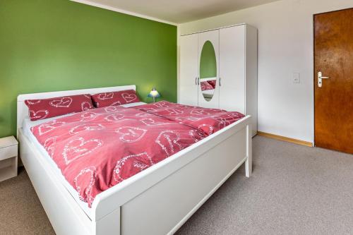 a bedroom with a bed with a pink comforter at Wiesenblick in Radolfzell am Bodensee