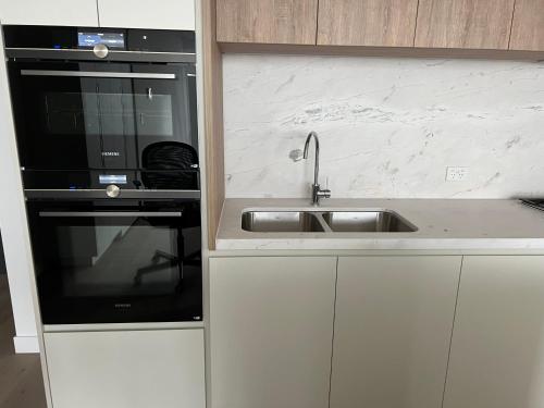 a kitchen with a sink and a microwave at WSP 3B2B apartment in CBD with free parking in Melbourne