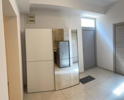 Cette chambre comprend un réfrigérateur et un miroir. dans l'établissement Apartment Park and Beach, à Igalo