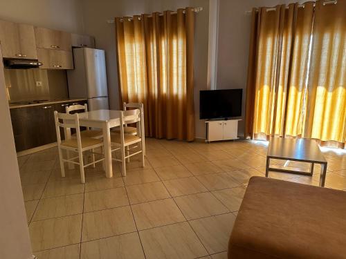 a living room with a table and chairs and a kitchen at Franklin Rooms in Sarandë