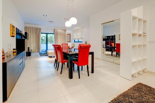 a kitchen and dining room with a table and red chairs at Seaside Oasis Your Own Private Getaway in St Julians in St Julian's