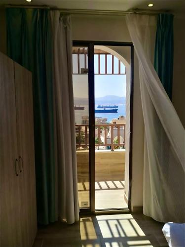 a room with a door open to a balcony with a view at Castle beach hotel in Aqaba