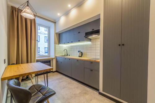 a kitchen with blue cabinets and a wooden table at Idea Design Apart-Hotel Prorizna in Kyiv