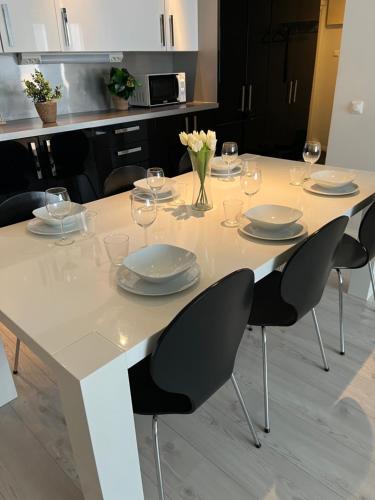 a white table with chairs and plates and wine glasses at Saunallinen kolmio Tampereen ydinkeskustassa in Tampere