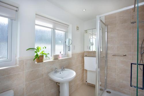 ein Bad mit einem Waschbecken und einer Dusche in der Unterkunft Holmdale House in Sidmouth