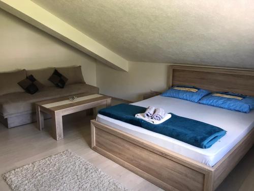 a bedroom with a large bed and a couch at Apartmani Dino Blagaj in Blagaj