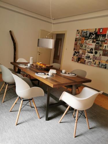 a dining room with a wooden table and white chairs at Ferienwohnung in Waldrandlage in Nationalpark Schleiden / Eifel in Schleiden