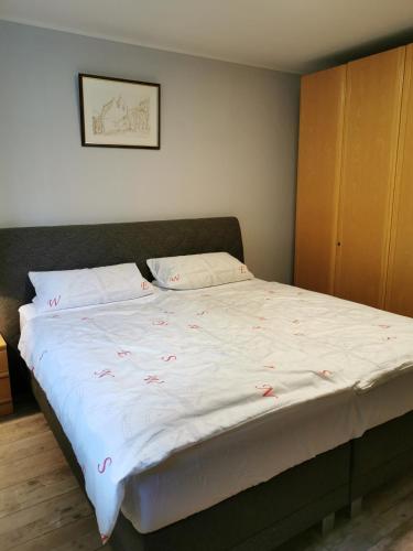 a bed with pink flowers on it in a room at Ferienwohnung in Waldrandlage in Nationalpark Schleiden / Eifel in Schleiden
