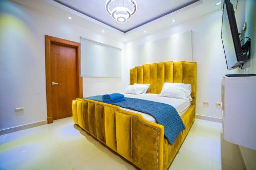 1 dormitorio con 1 cama con cabecero amarillo en SFMverdana Rental en San Francisco de Macorís