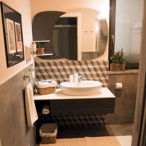 uma casa de banho com um lavatório e um espelho em B&B Belelì Daramba em Cuneo