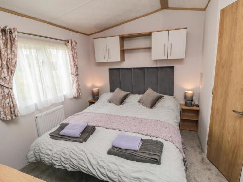 a bedroom with a large bed with two towels on it at Lodge 7 - Seabreeze Retreat in Bridlington