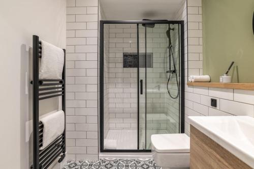 a bathroom with a glass shower and a toilet at Remodelled Luxury 3 Bed Apartment in Aberdeen
