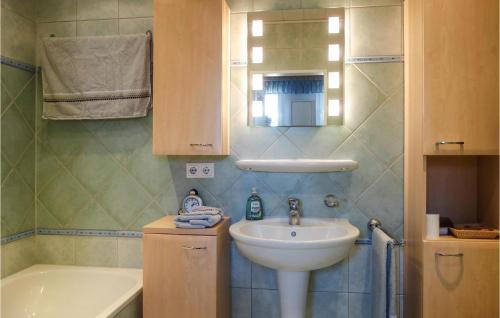 a small bathroom with a sink and a bath tub at 3 Bedroom Lovely Home In Schortens in Schortens