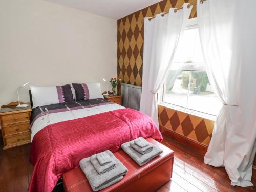 una camera da letto con un letto con una coperta rossa e una finestra di Sunningdale a Worcester
