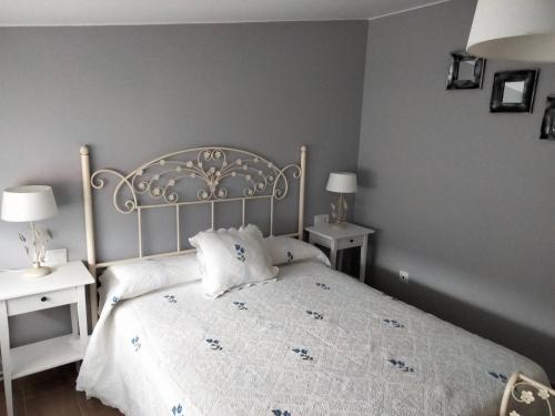 ein Schlafzimmer mit einem weißen Bett mit zwei Tischen und zwei Lampen in der Unterkunft A de Sabardes in Sabardes