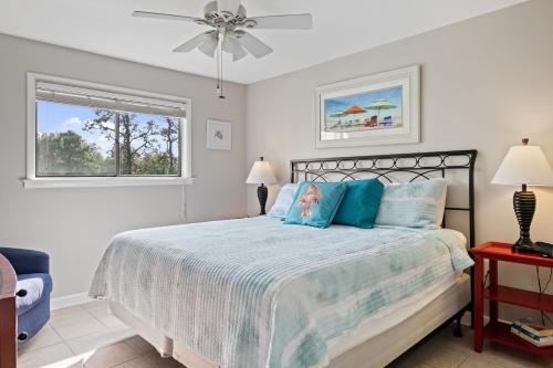 a bedroom with a bed with blue pillows and a window at Beachfront Family Condo Near Golfing and Shopping! in Hilton Head Island