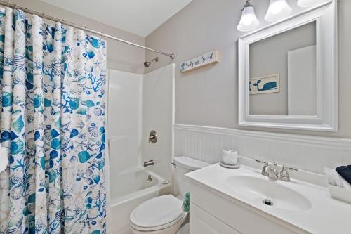 a bathroom with a toilet sink and a shower curtain at Steps to Pool and Beach Family Condo in Hilton Head in Hilton Head Island