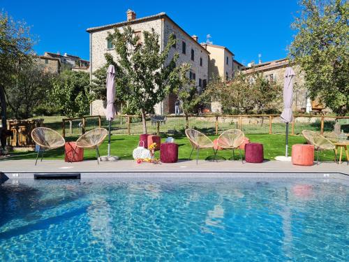 a group of chairs sitting next to a swimming pool at Agriturismo La Via Dell'Oliviera in Ciciano