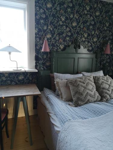 een slaapkamer met een bed, een bureau en een raam bij North Wing - Sviten in Enköping