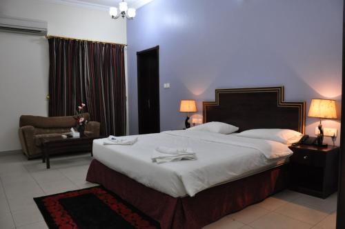 a bedroom with a large bed with two towels on it at Sahara Hotel Apartments in Muscat