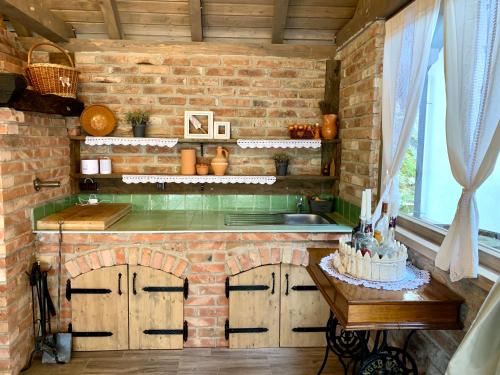eine gemauerte Küche mit einer Theke und einem Tisch in der Unterkunft Vila Countryhouse Pijevci in Novi Marof