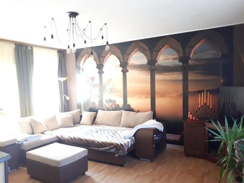 a living room with a couch and a painting on the wall at Nati Nagy Apartman in Siófok
