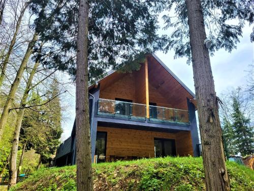 una casa construida en la cima de una colina con árboles en Adventure Lake Resort - Simared en Baia Mare