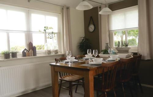 een eetkamer met een tafel, stoelen en ramen bij Ons Binkje in Loon op Zand