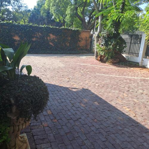 a shadow of a person on a brick driveway at Moonlight Guesthouse in Pretoria