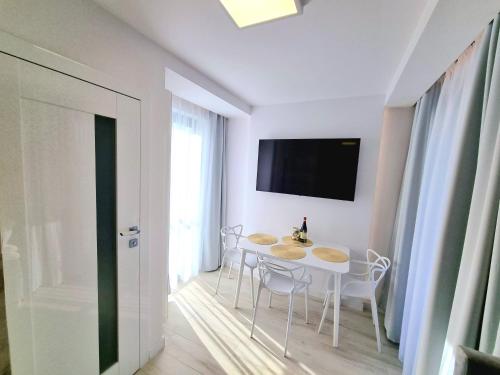 a white dining room with a table and chairs at Baltic Soul Villa in Międzyzdroje